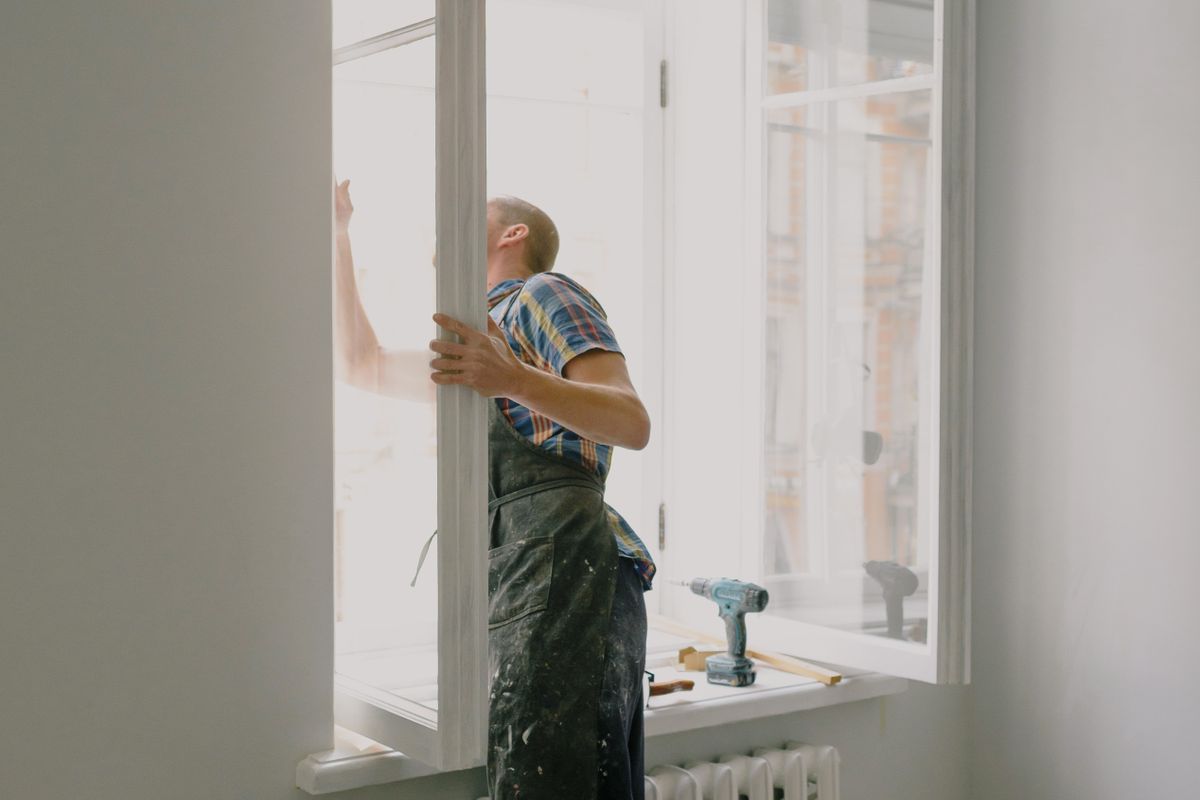 Window installer fitting a new window in a District of Columbia home
